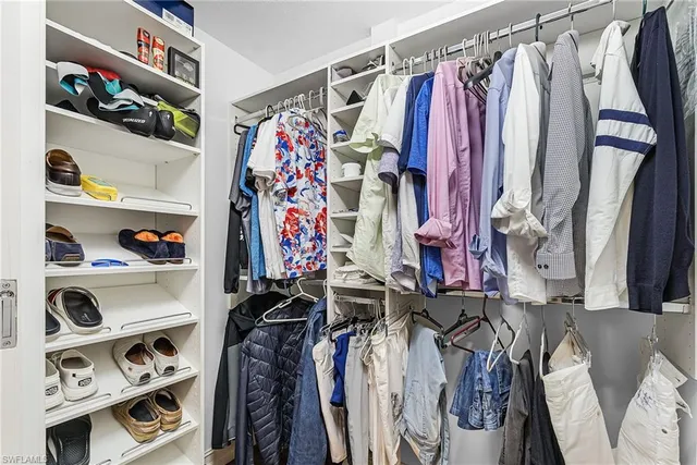 a view of walk in closet with clothes and shoes