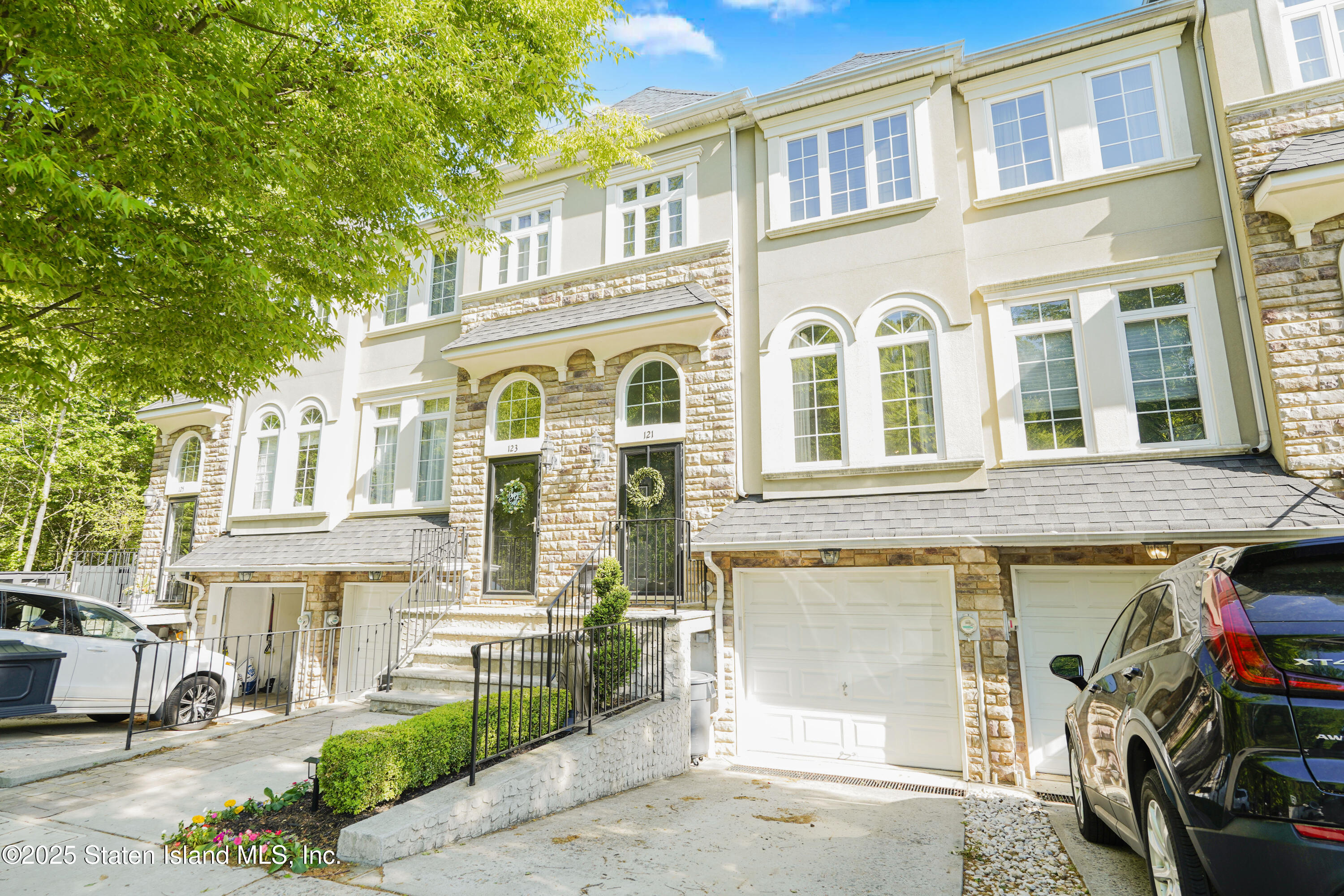 121 Presentation Circle Staten Island, NY 10312 - Photo 2 of 39 a front view of a residential apartment building with a yard and parking space