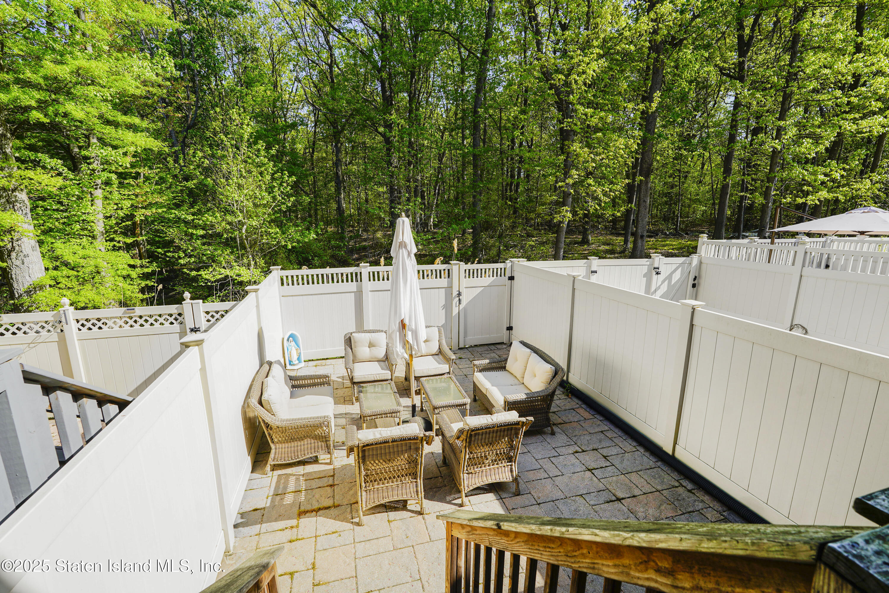 121 Presentation Circle Staten Island, NY 10312 - Photo 35 of 39 a view of a patio with table and chairs with wooden floor and fence