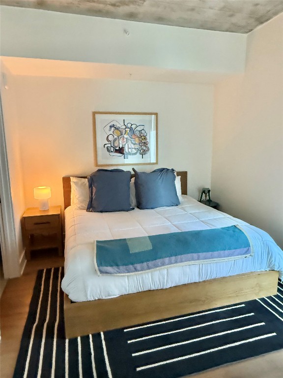 48 East Avenue, Unit 2509 Austin, TX 78701 - Photo 15 of 30 a bedroom with a bed and wooden floor