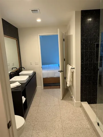 a bathroom with a sink a toilet and shower