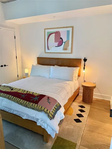 a bedroom with a bed and a painting on the wall