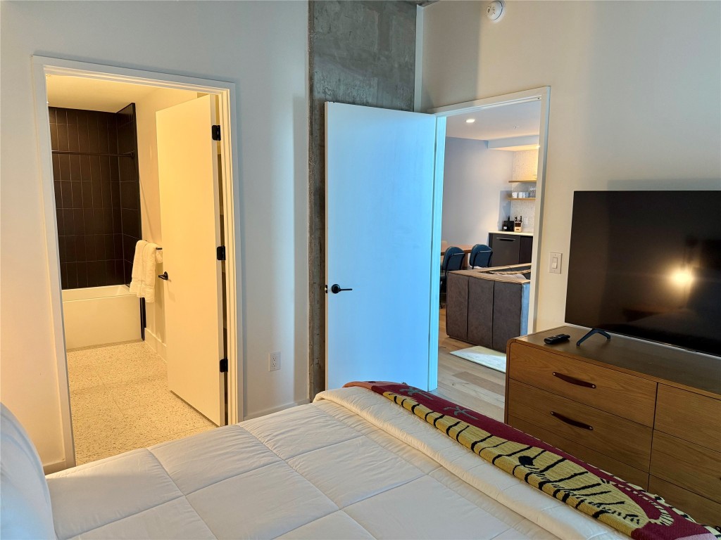 48 East Avenue, Unit 2509 Austin, TX 78701 - Photo 7 of 30 a bedroom with a bed and a television