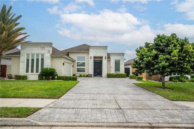 a view of a white house with a yard and plants