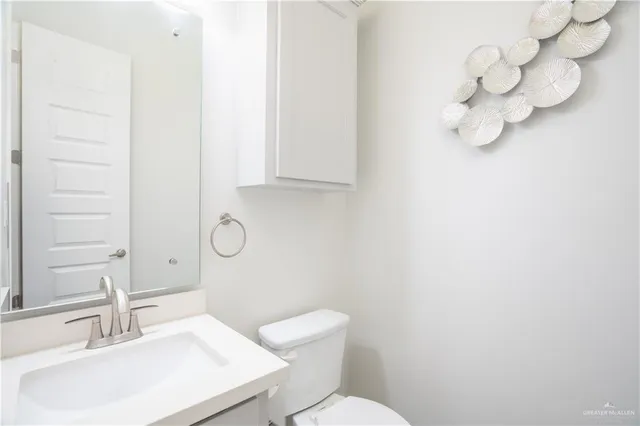 a bathroom with a sink vanity mirror and toilet