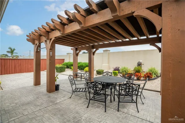a view of a patio with a table and chairs and a barbeque