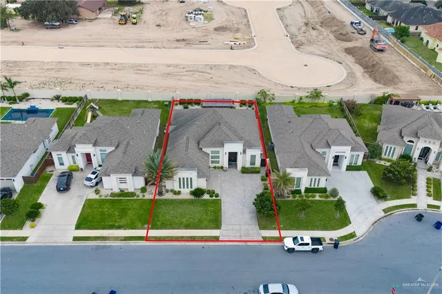 an aerial view of multiple houses with a yard