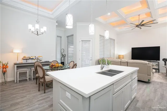 a living room with stainless steel appliances kitchen island granite countertop furniture and a flat screen tv