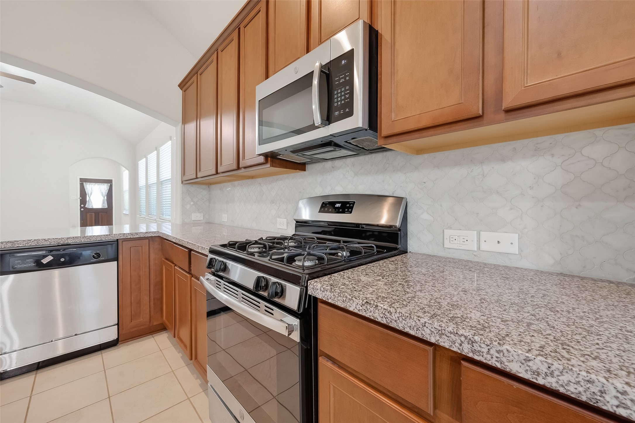 7631 Granite Terrace Lane Houston, TX 77083 - Photo 21 of 46 a kitchen with stainless steel appliances granite countertop a stove a microwave and a sink