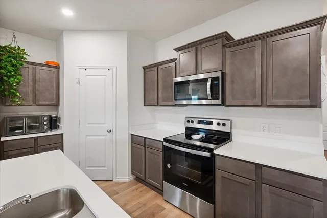 a kitchen with a sink stove and microwave