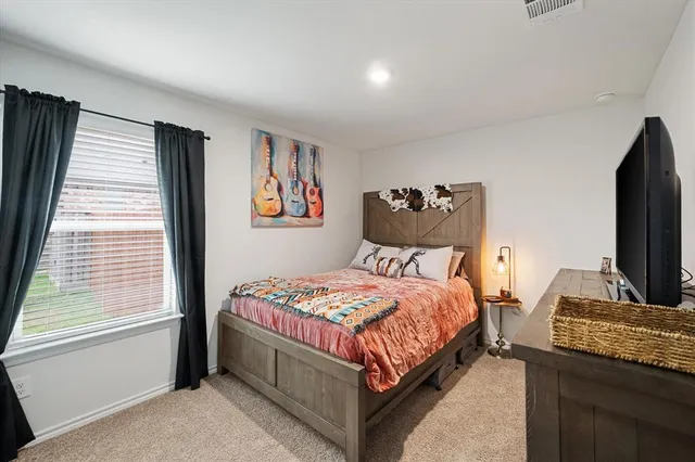 a bedroom with a bed and a flat screen tv