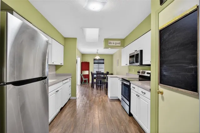 a kitchen with stainless steel appliances a refrigerator sink and microwave