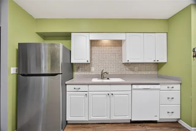 a view of a kitchen with cabinets and stainless steel appliances