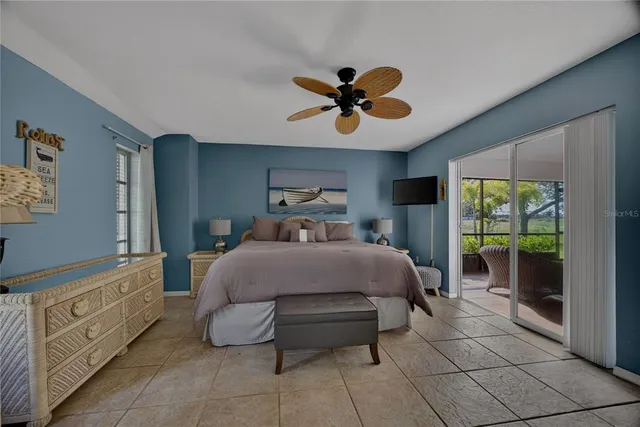 a bedroom with a bed a mirror on the dresser and a chandelier