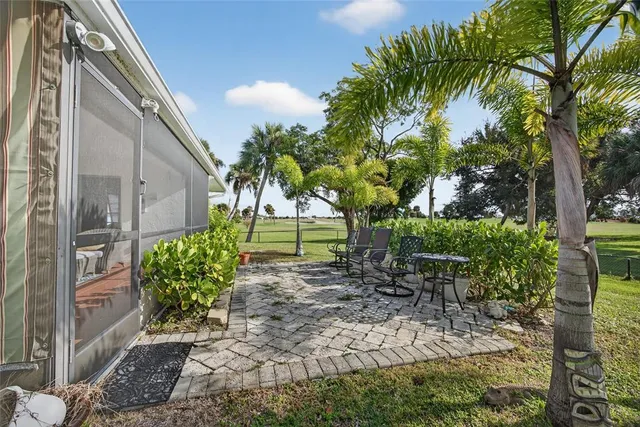 a view of a back yard with a table and chair and potted plants
