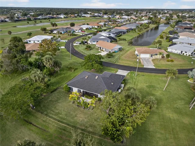 an aerial view of residential houses with outdoor space and trees