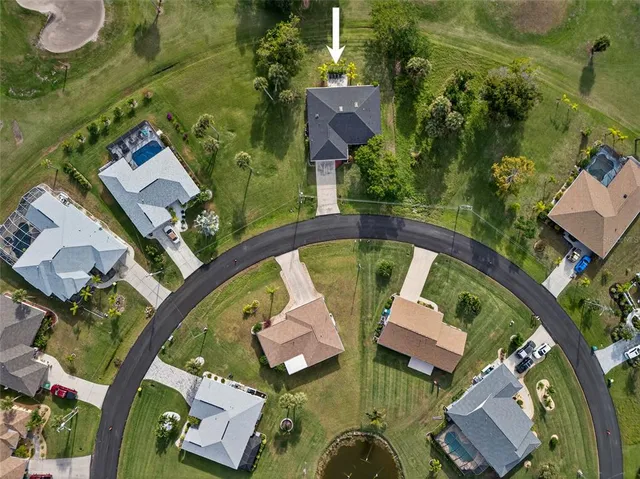 an aerial view of a house with garden space and swimming pool