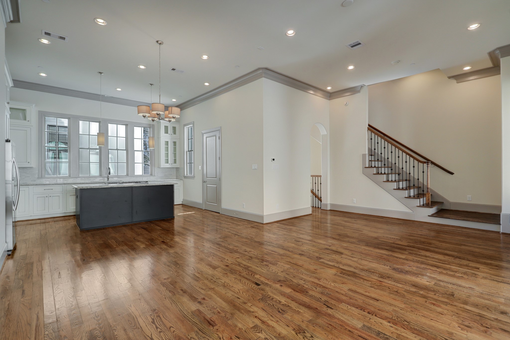 4838 Austin Street Houston, TX 77004 - Photo 11 of 27 a view of an empty room with wooden floor and a kitchen