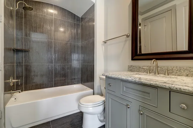 a bathroom with a granite countertop sink toilet and shower