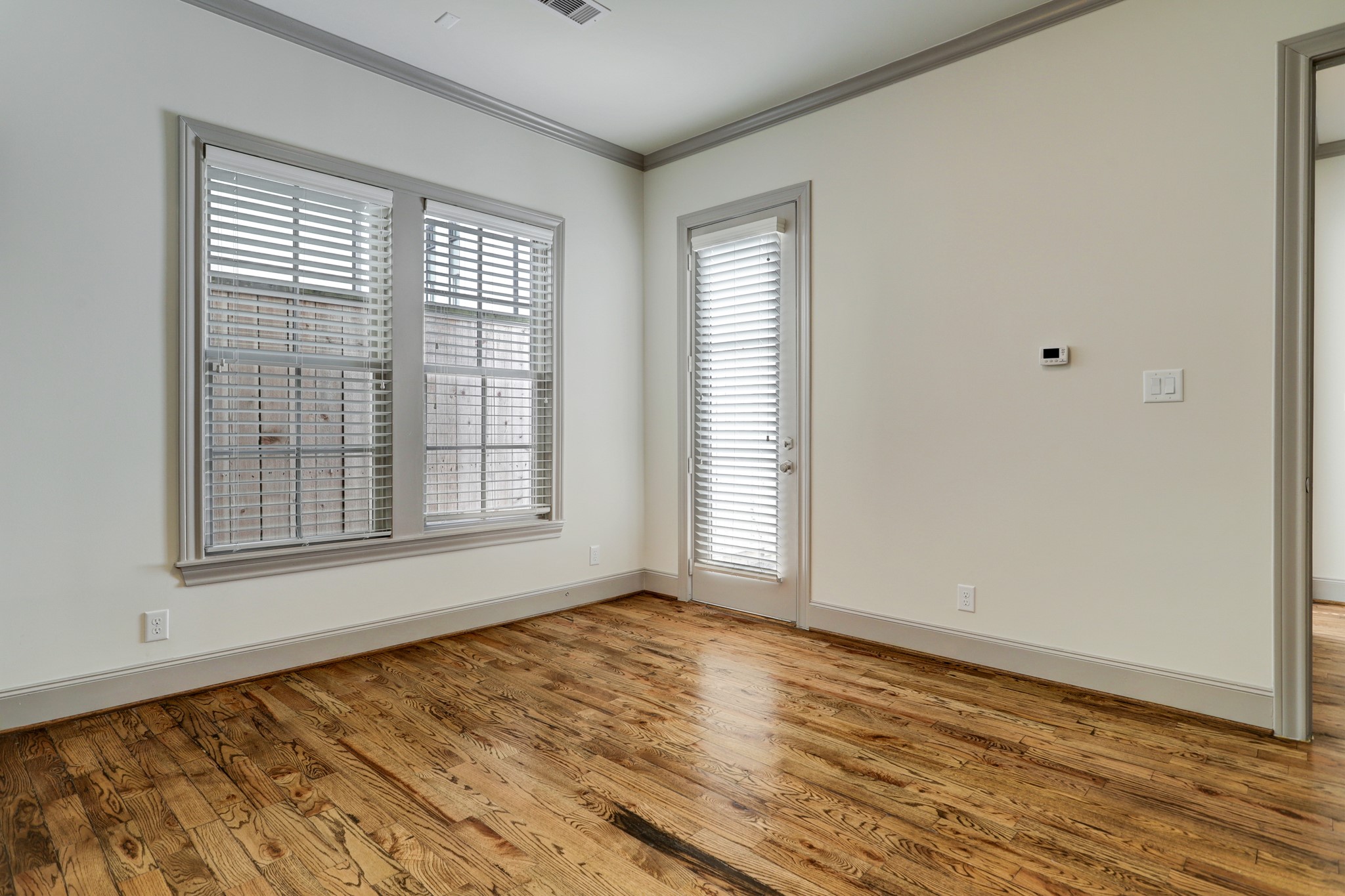 4838 Austin Street Houston, TX 77004 - Photo 5 of 27 a view of an empty room with wooden floor and a window