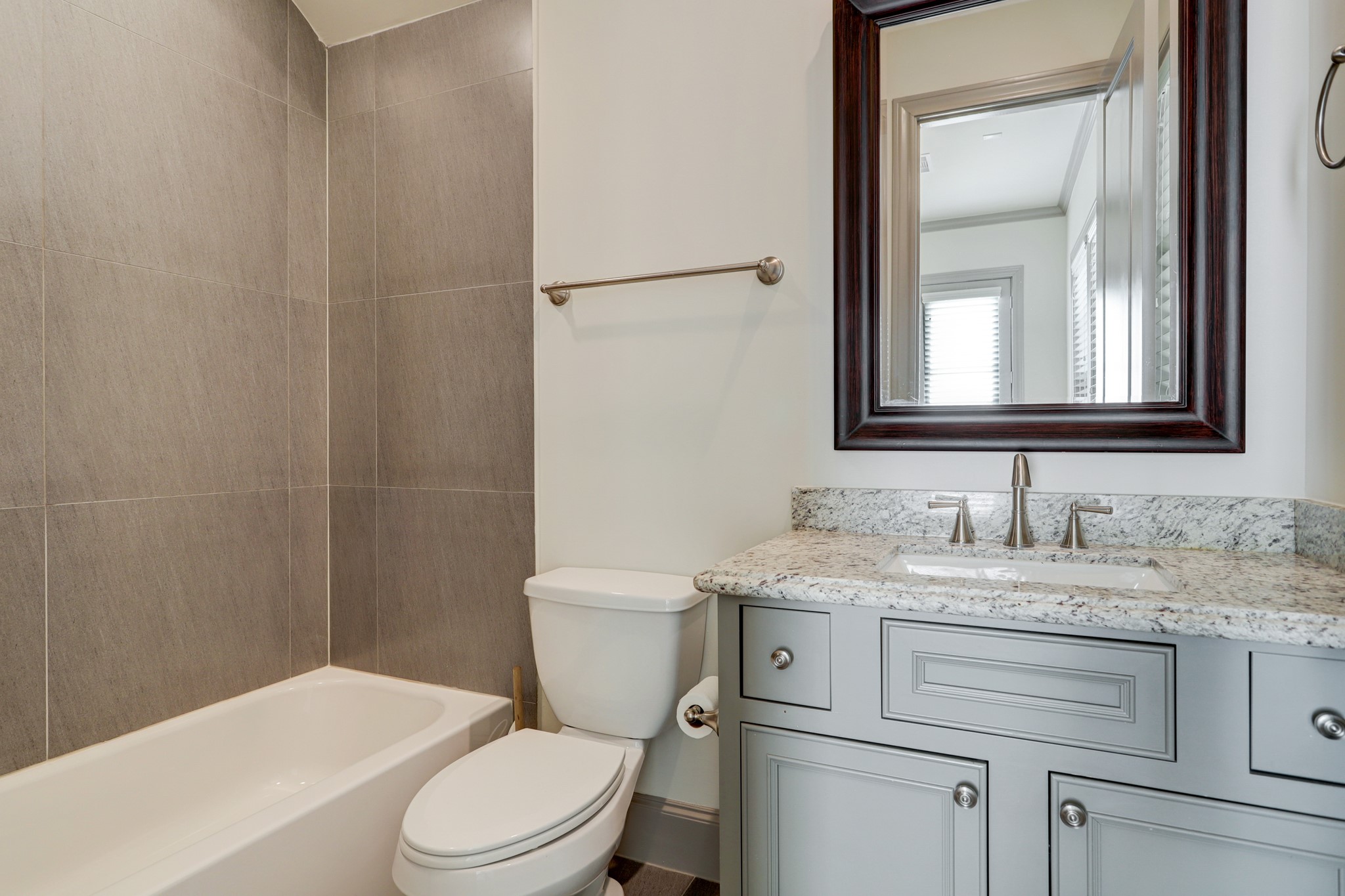 4838 Austin Street Houston, TX 77004 - Photo 6 of 27 a bathroom with a granite countertop toilet sink and mirror