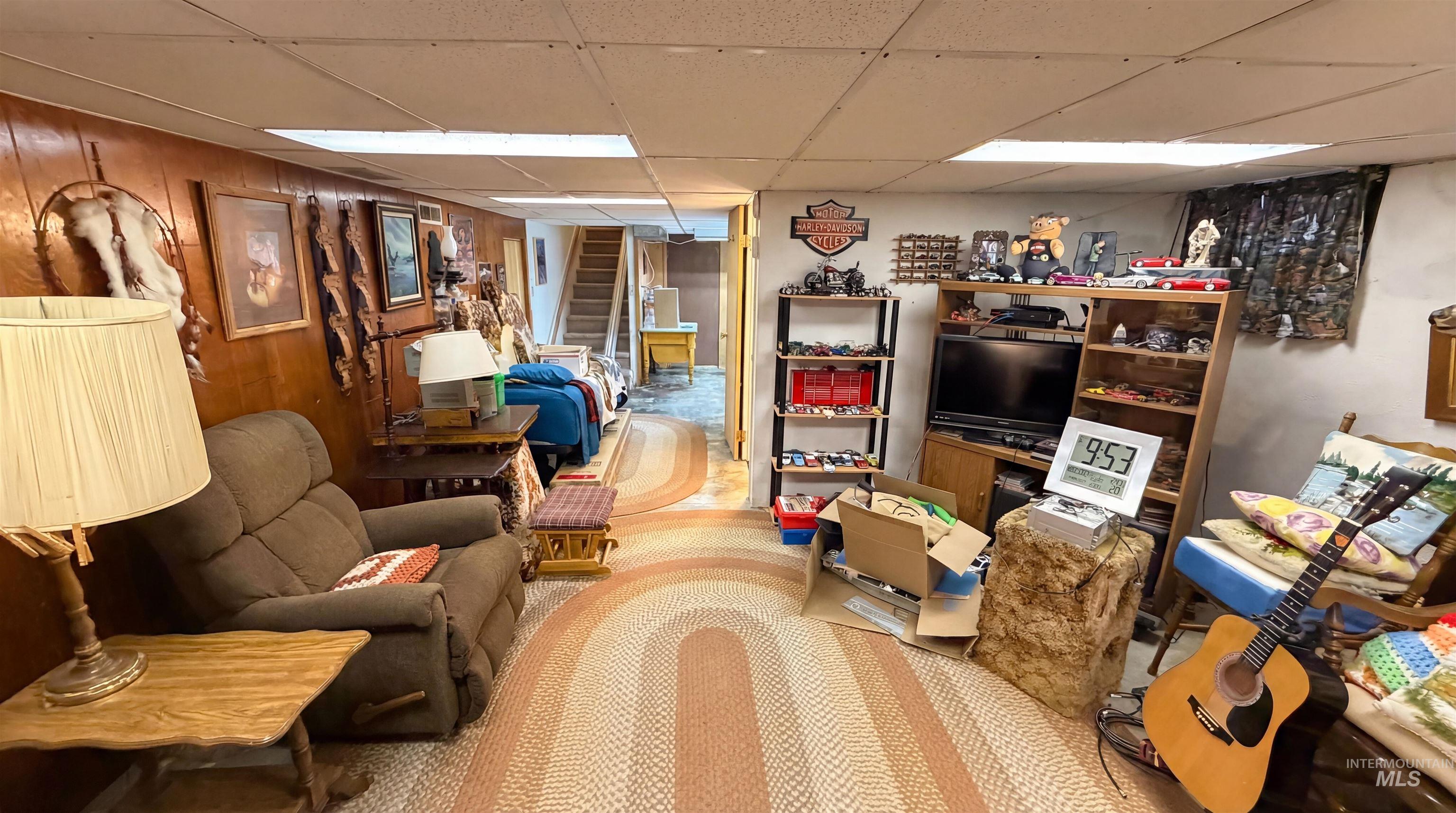 19076 Pleasant Avenue Caldwell, ID 83607 - Photo 27 of 37 Living area with stairs, a drop ceiling, and wood walls