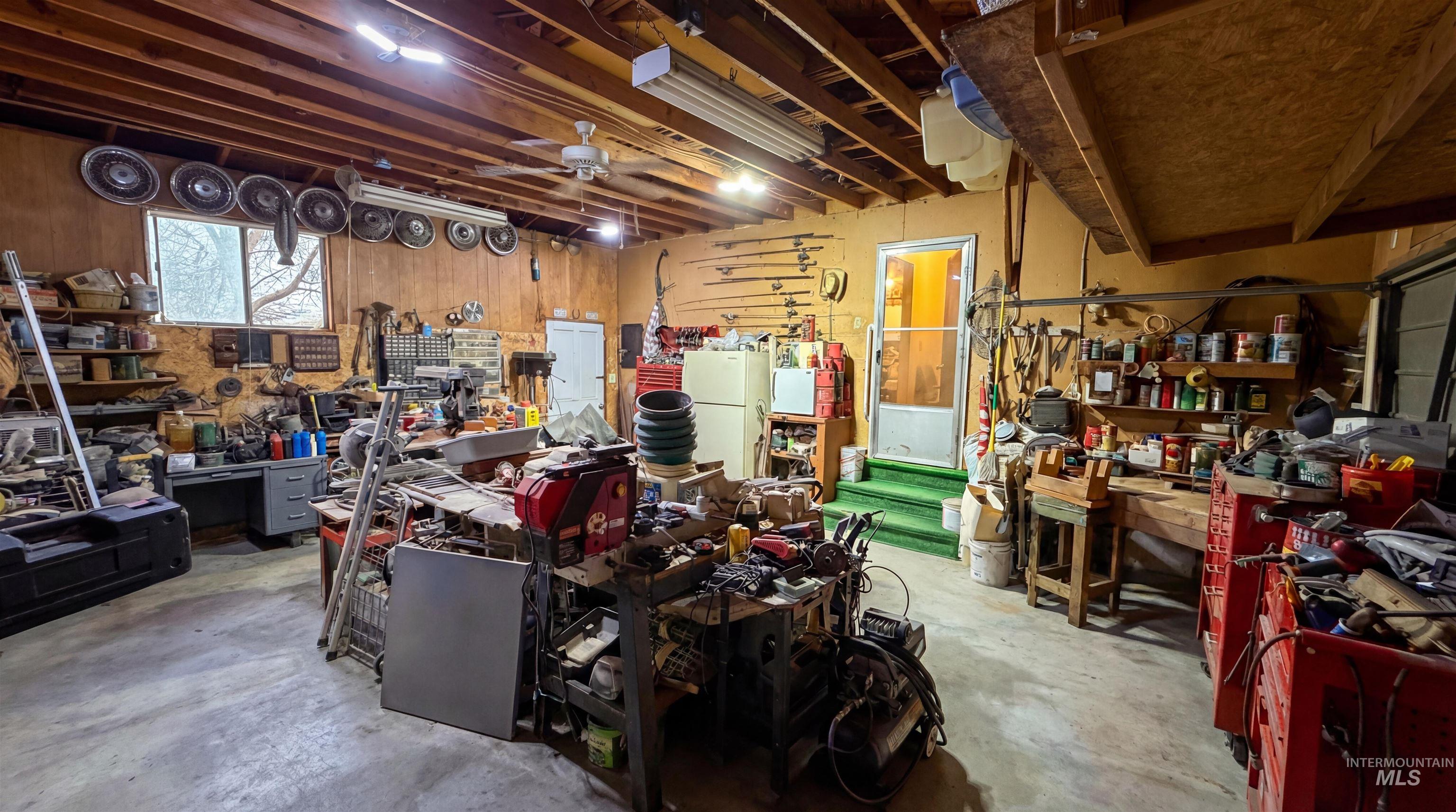 19076 Pleasant Avenue Caldwell, ID 83607 - Photo 28 of 37 Garage featuring a workshop area, freestanding refrigerator, and a ceiling fan
