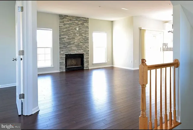 a view of a livingroom with wooden floor and a fireplace