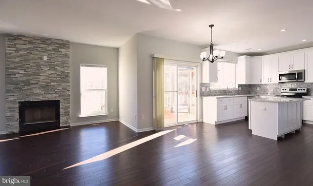 a open kitchen with a refrigerator a stove a microwave and cabinets