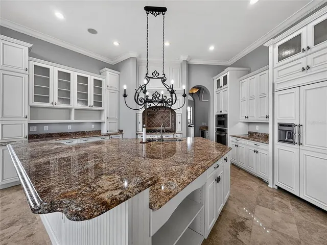 a kitchen with stainless steel appliances granite countertop a sink refrigerator and cabinets