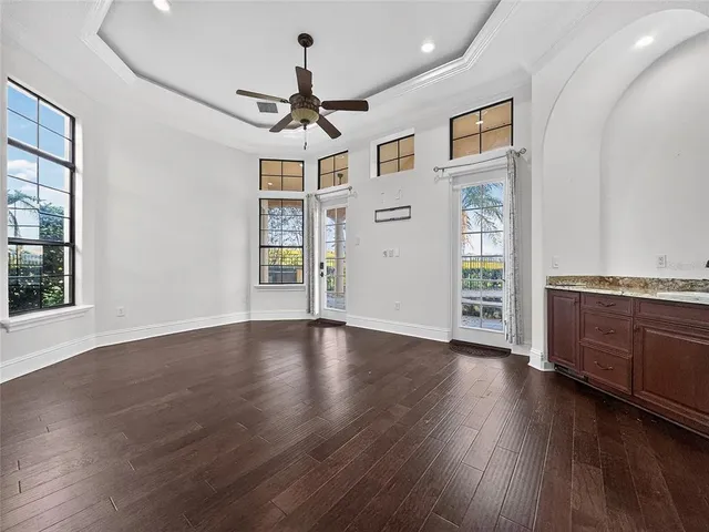 a view of an empty room with window and wooden floor