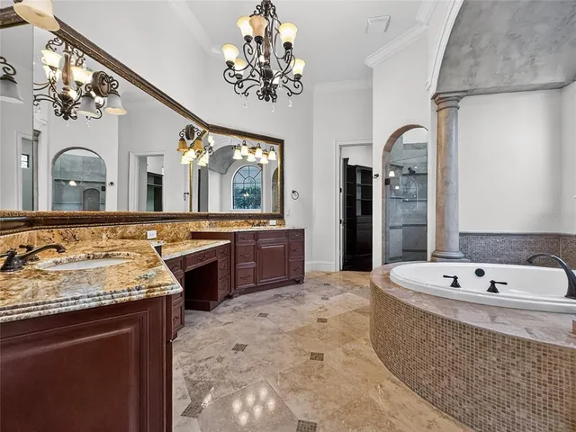 a spacious bathroom with a tub sink and mirror