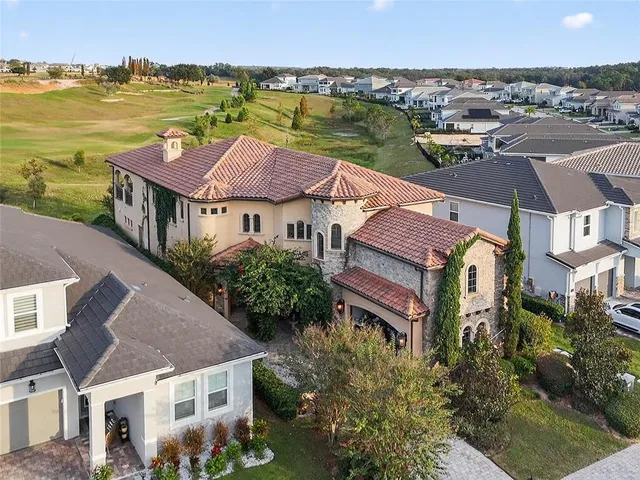 an aerial view of multiple houses with a lake