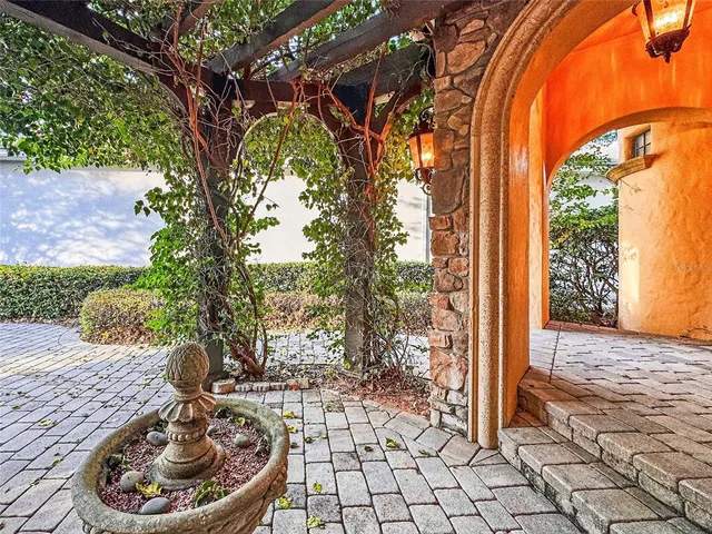a patio with table and chairs and potted plants