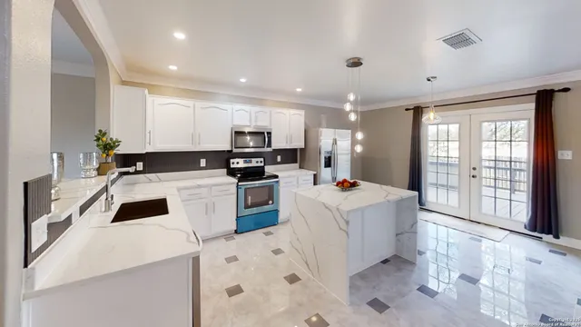 a kitchen that has a lot of cabinets a sink and a stove in it