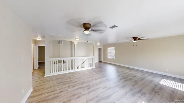 a view of an empty room with wooden floor
