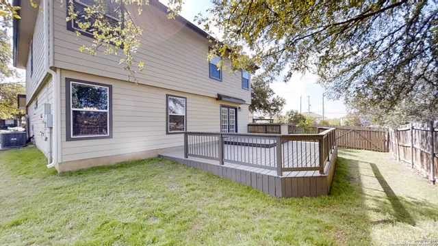 a view of a house with wooden fence and a fence