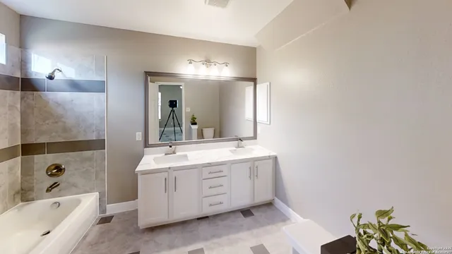 a bathroom with a tub a sink and a large mirror