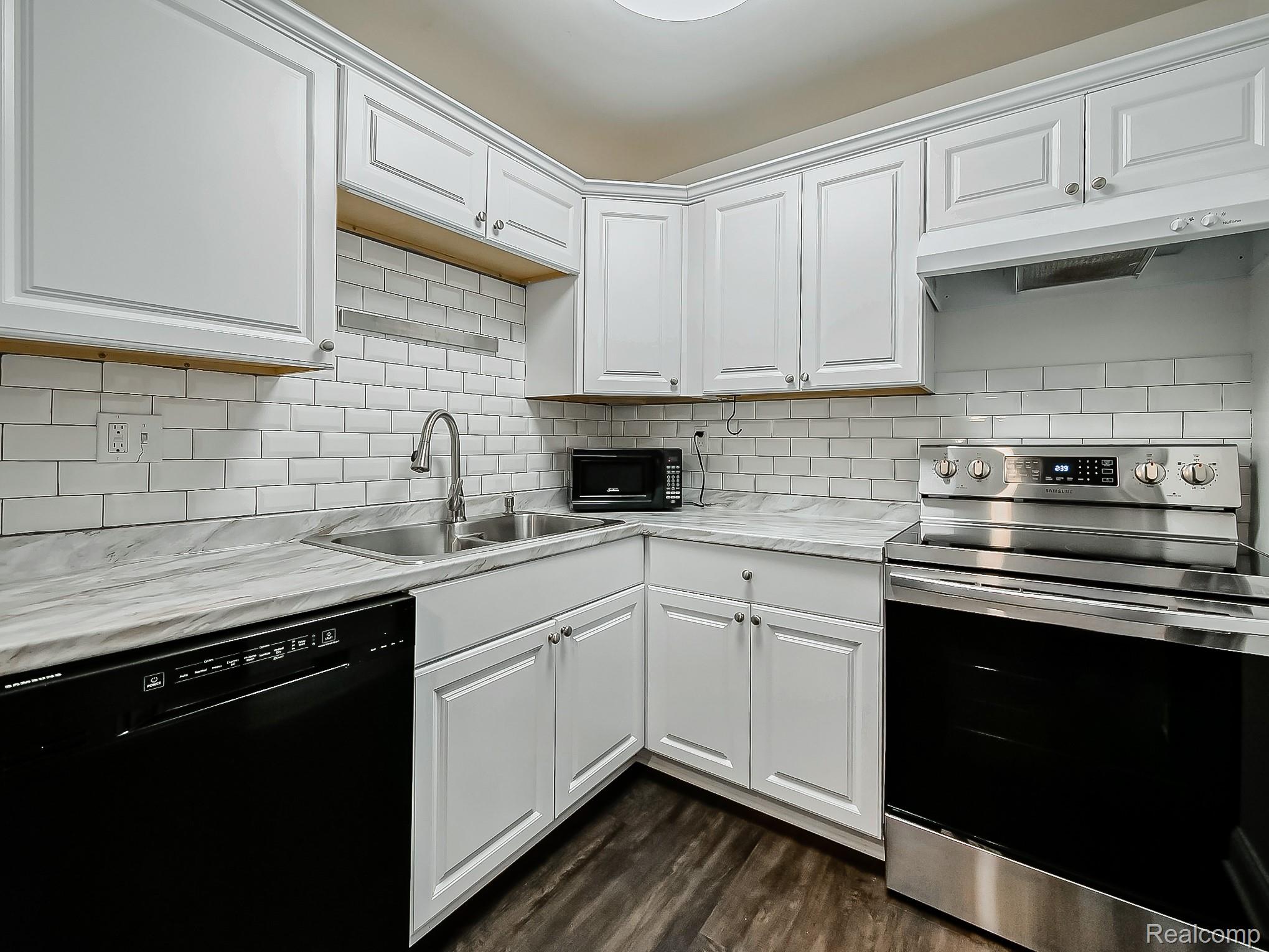 4905 South Crooks Road Royal Oak, MI 48073 - Photo 8 of 28 Kitchen featuring black appliances, light countertops, white cabinets, and dark wood-style floors