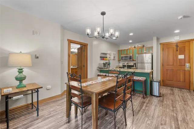 a view of a dining room with furniture a chandelier and wooden floor