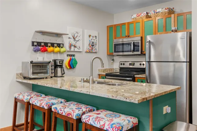 a kitchen with stainless steel appliances granite countertop a sink refrigerator and microwave