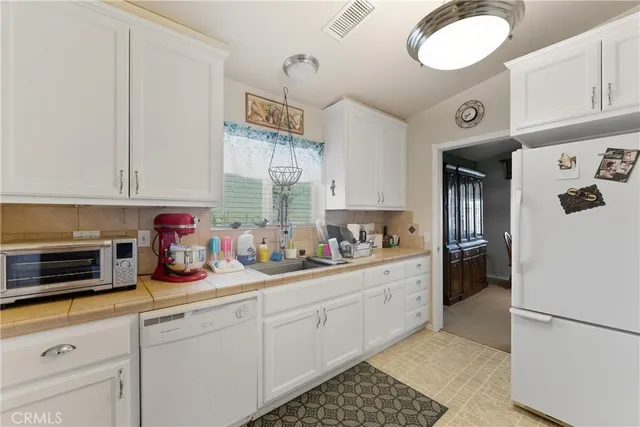a kitchen with refrigerator and cabinets