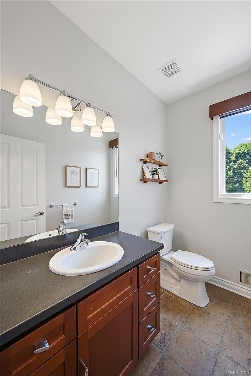 1422 Galena Rochester, MI 48306 - Photo 25 of 73 Bathroom featuring a wood-finish vanity with a built-in sink, dark countertop, and tile flooring