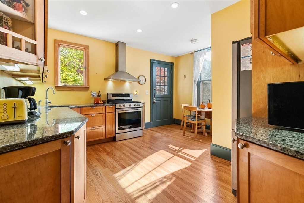 72 Cypress Street, Unit 1 Brookline, MA 02445 - Photo 15 of 23 a kitchen with stainless steel appliances granite countertop sink stove top oven and cabinets