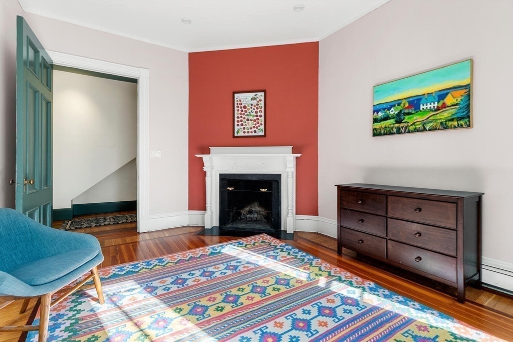 72 Cypress Street, Unit 1 Brookline, MA 02445 - Photo 9 of 23 a bedroom with a bed and a fireplace