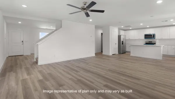 a view of a kitchen with kitchen island wooden floor appliances and a window