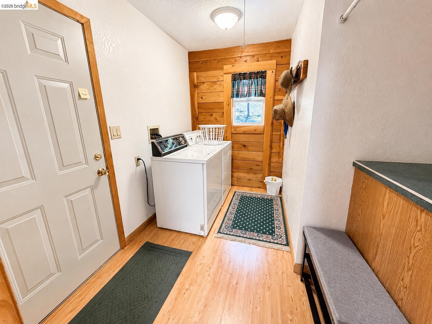 21181 Phoenix Lake Road Sonora, CA 95370 - Photo 21 of 34 Dedicated laundry area featuring wood-finish flooring, a bright window, and built-in shelving with a countertop