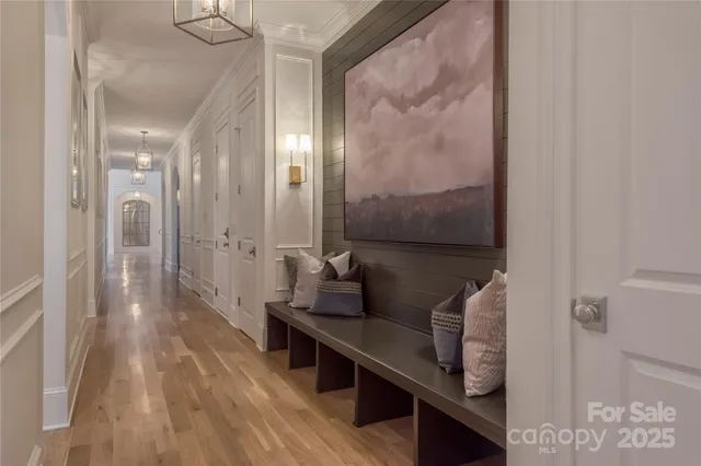 a hallway with white cabinets and wooden floor