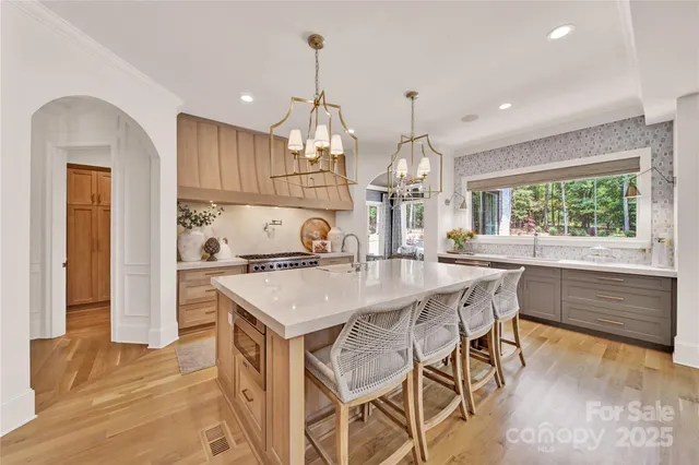 a kitchen with kitchen island a large counter top space and stainless steel appliances
