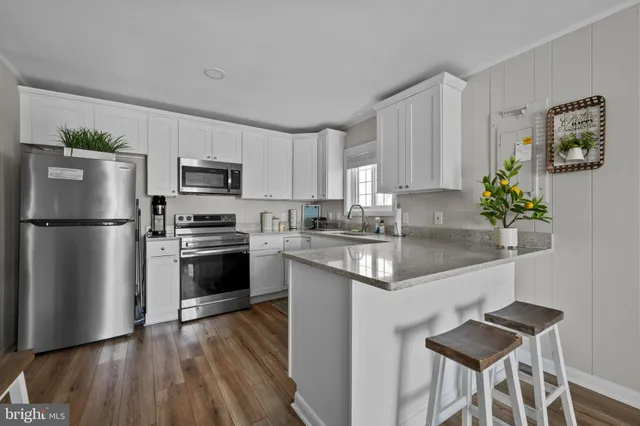 a kitchen with granite countertop a refrigerator stove and microwave